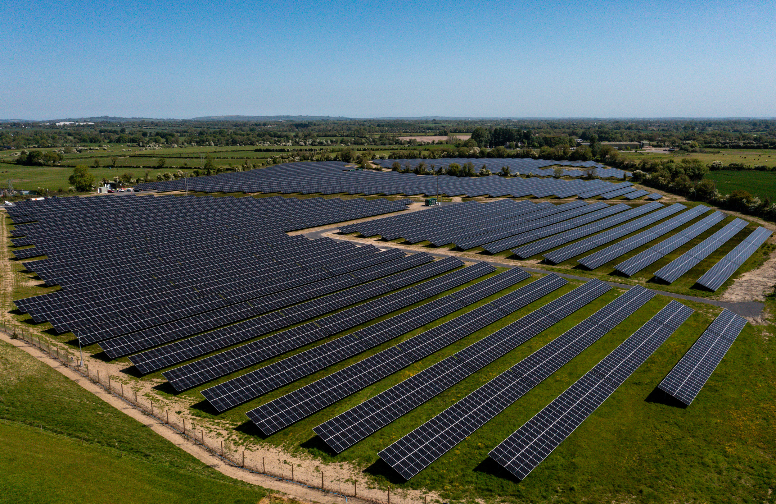 Solar farm aerial view with trees and grass